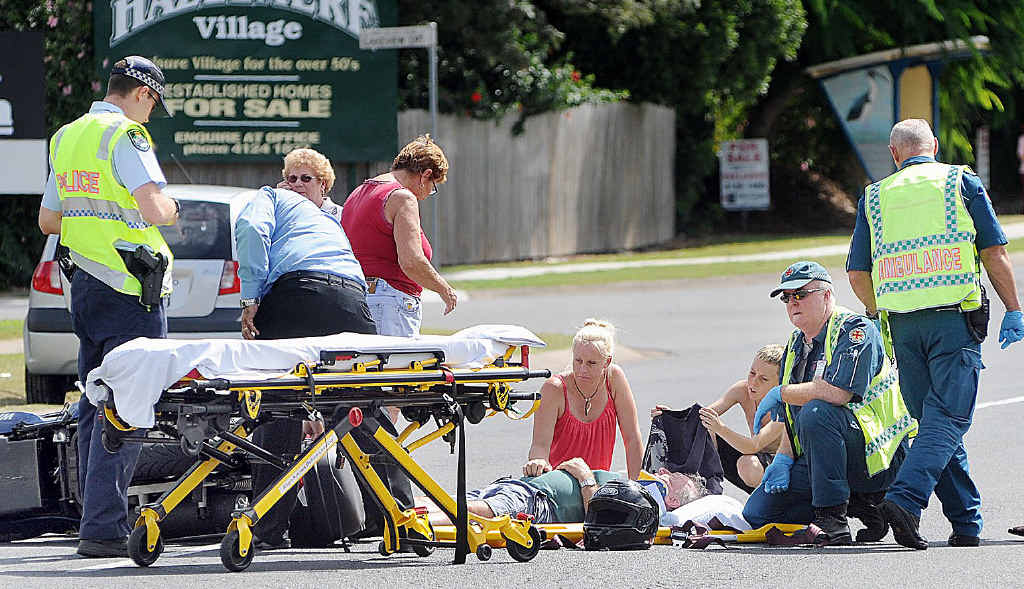 Danni Bramble (kneeling) and Jordan Te-Wake assist ambulance officers after a motorcyclist was hit by a car at Eli Waters yesterday. Danni Bramble (kneeling) and Jordan Te-Wake assist ambulance officers after a motorcyclist was hit by a car at Eli Waters yesterday.